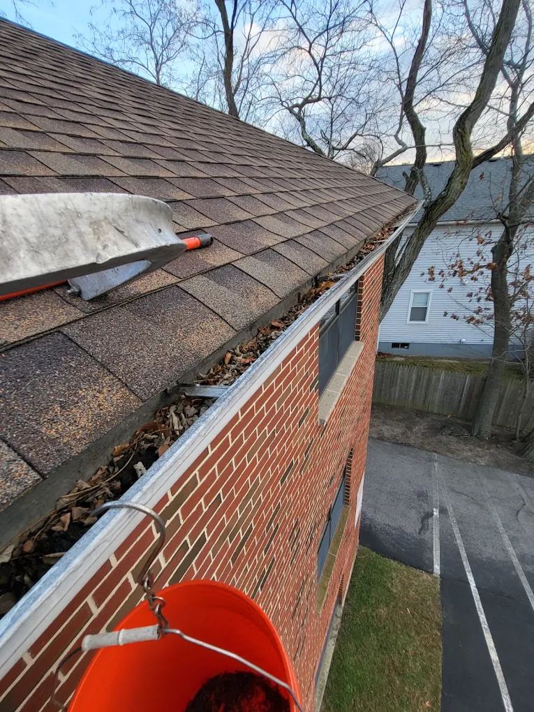 Gutter cleaning in progress on a brick home